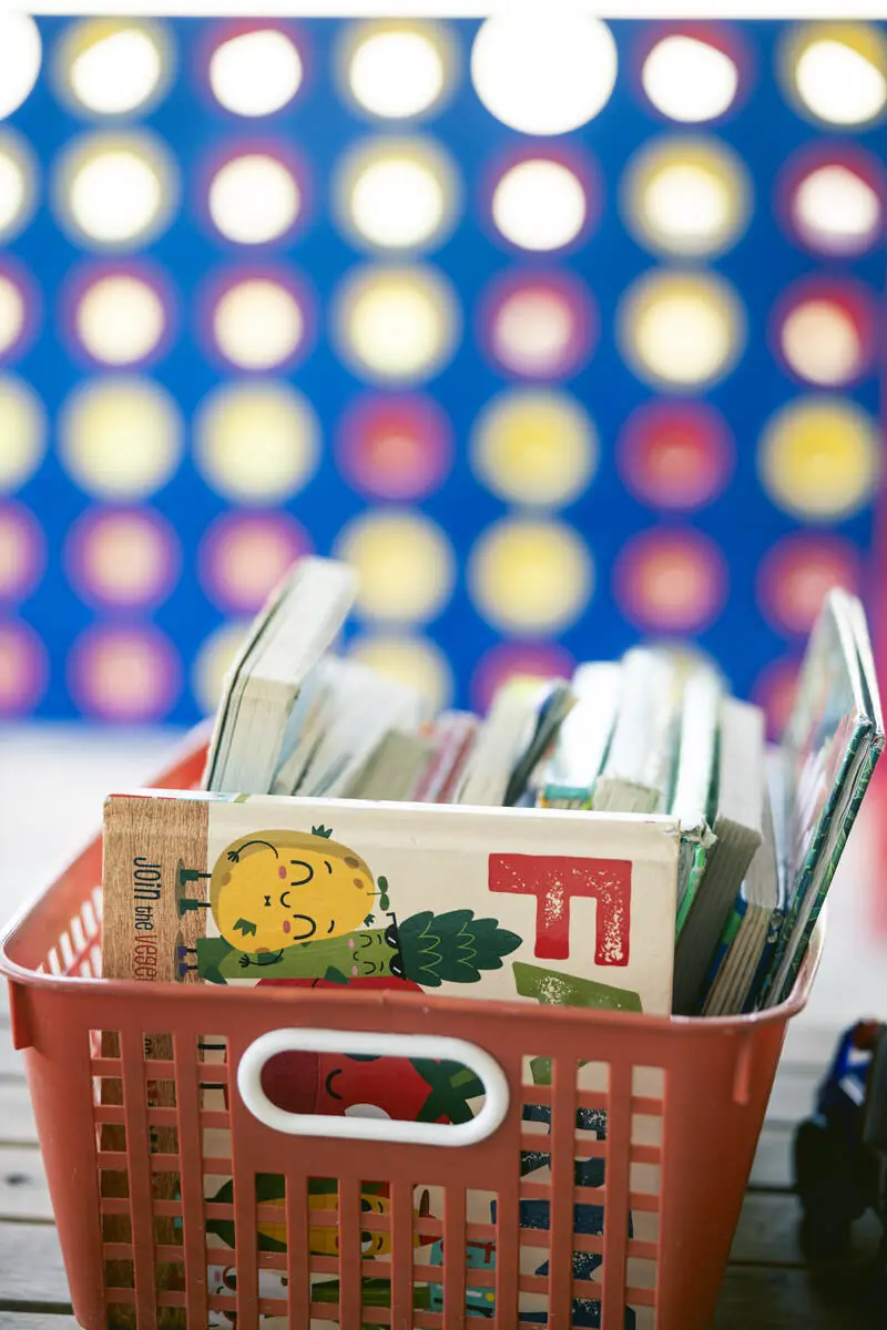 Basket of kids books beside the giant Connect Four game