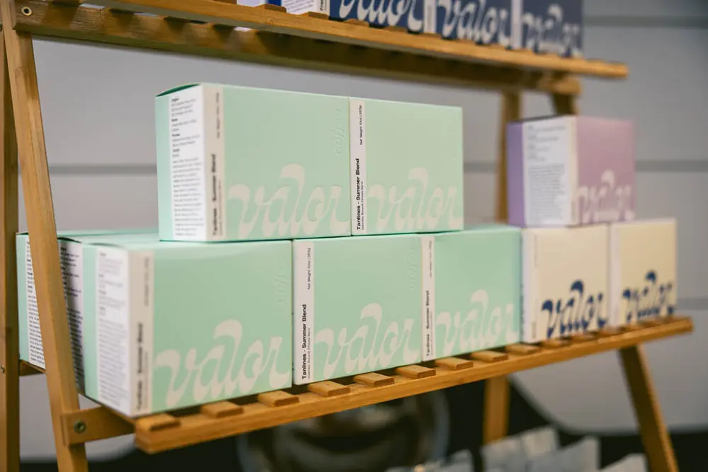 Boxes of Valor Coffee beans, including the Tanlines summer blend, on the retail shelf at Good Fruit in Tampa